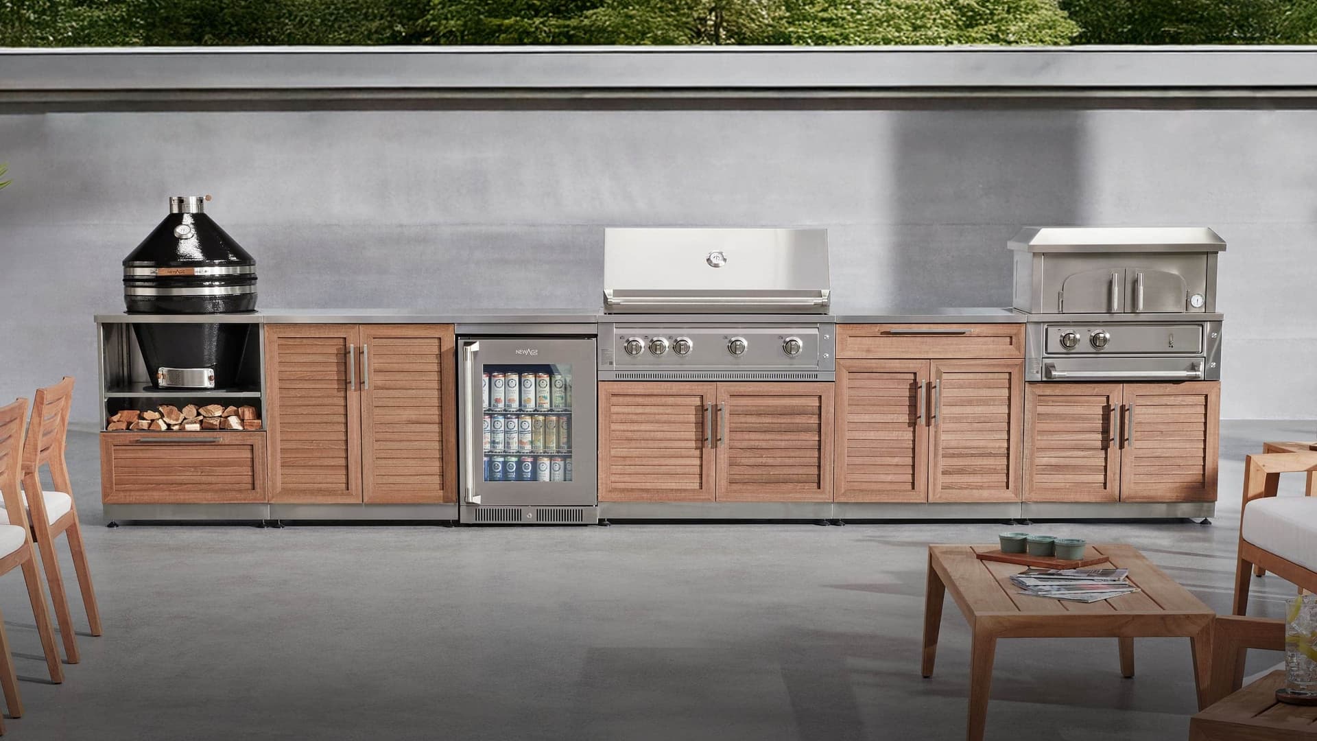 NewAge outdoor kitchen with wood-look louvered cabinets, a kamado grill, stocked beverage fridge, built-in gas grill and pizza oven