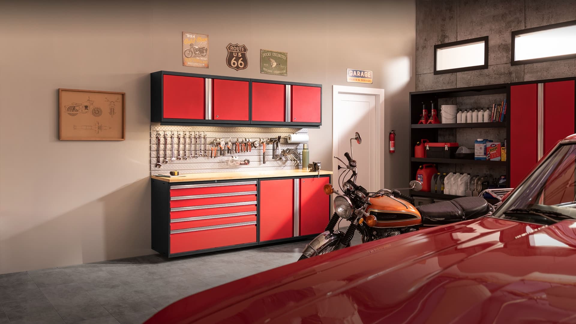 NewAge grey garage cabinets with a stainless-top workbench and an overhead tire rack