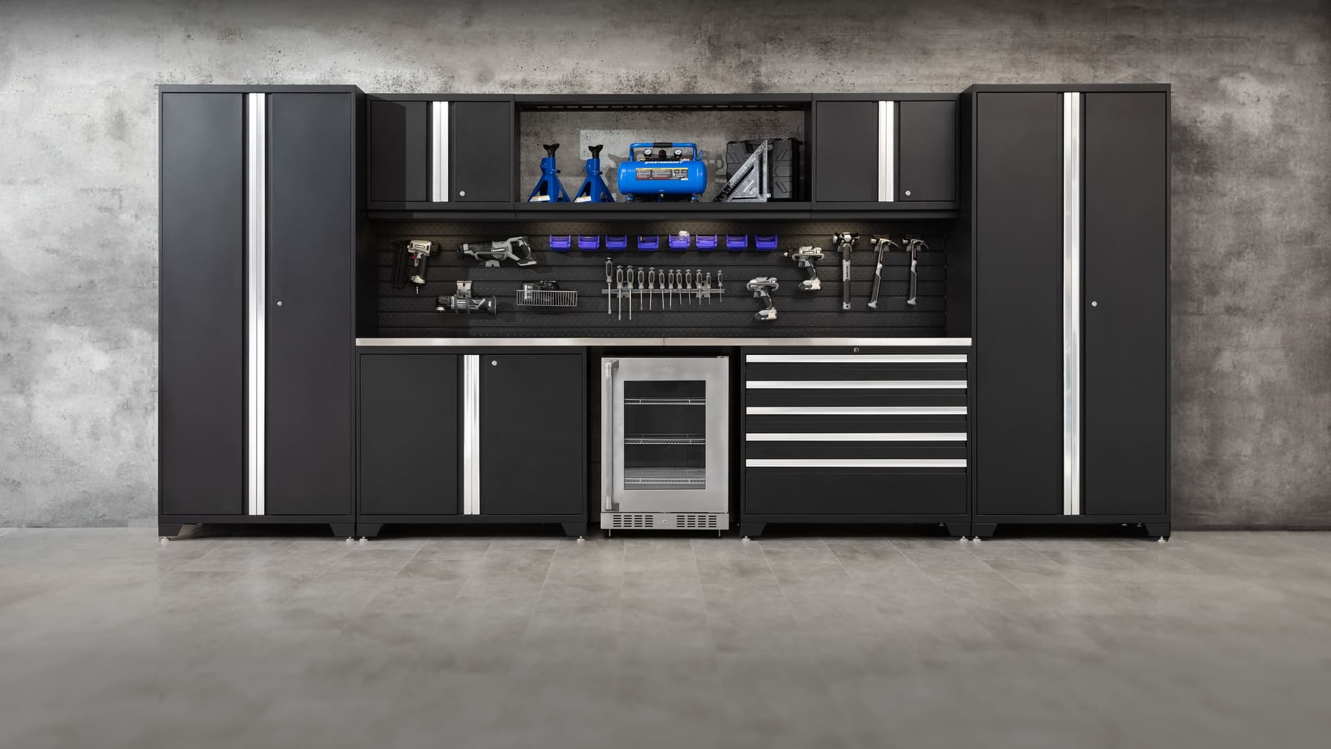 NewAge grey garage cabinets with a stainless-top workbench and an overhead tire rack